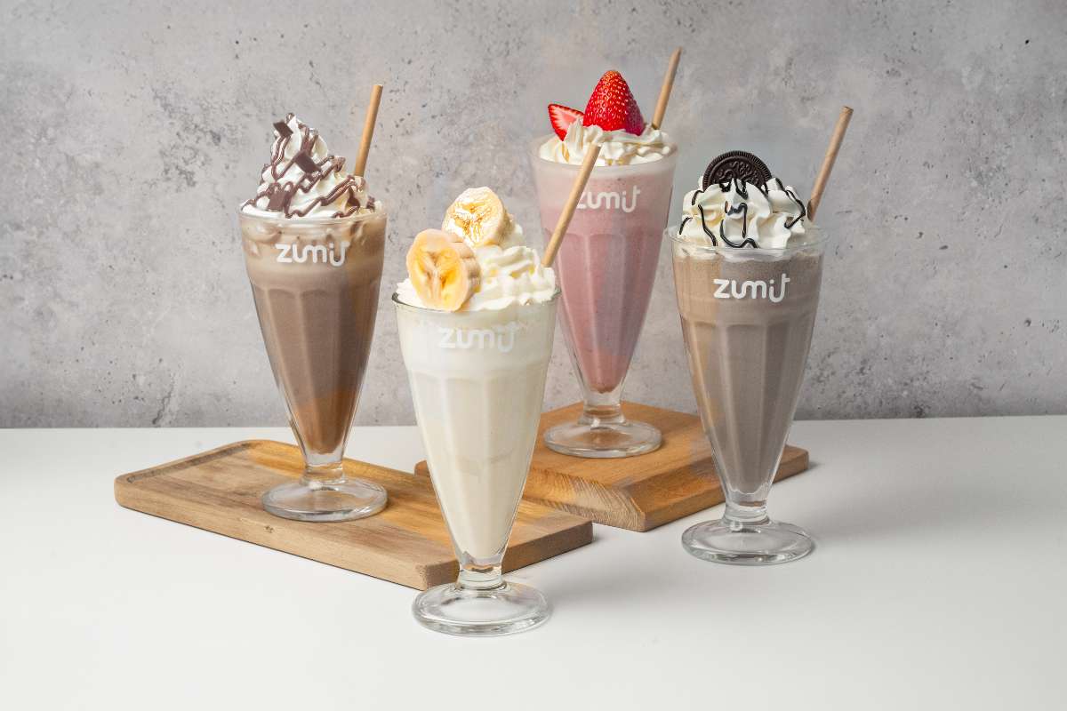Milkshakes Zumit en una tabla de madera y mesa blanca